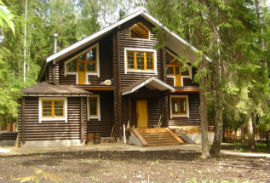 серый деревянный дом с желтыми окнами
